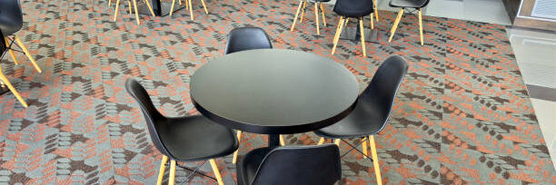 Wide angle photo of cafeteria with tables and chairs